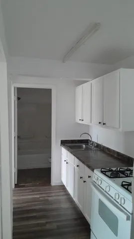 a kitchen with granite countertop white cabinets and white appliances