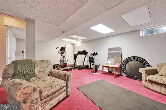 a living room with furniture gym equipment and a chandelier
