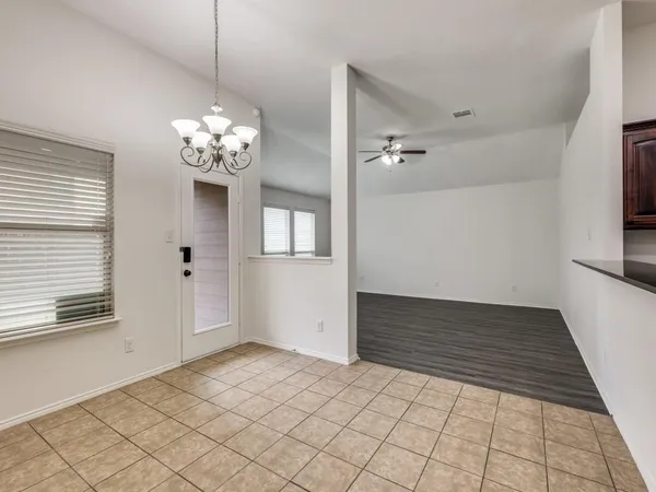 a view of a livingroom with a chandelier fan and windows