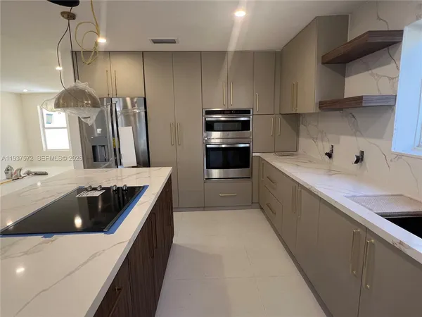 a kitchen with kitchen island a sink dishwasher stove and refrigerator with wooden cabinet