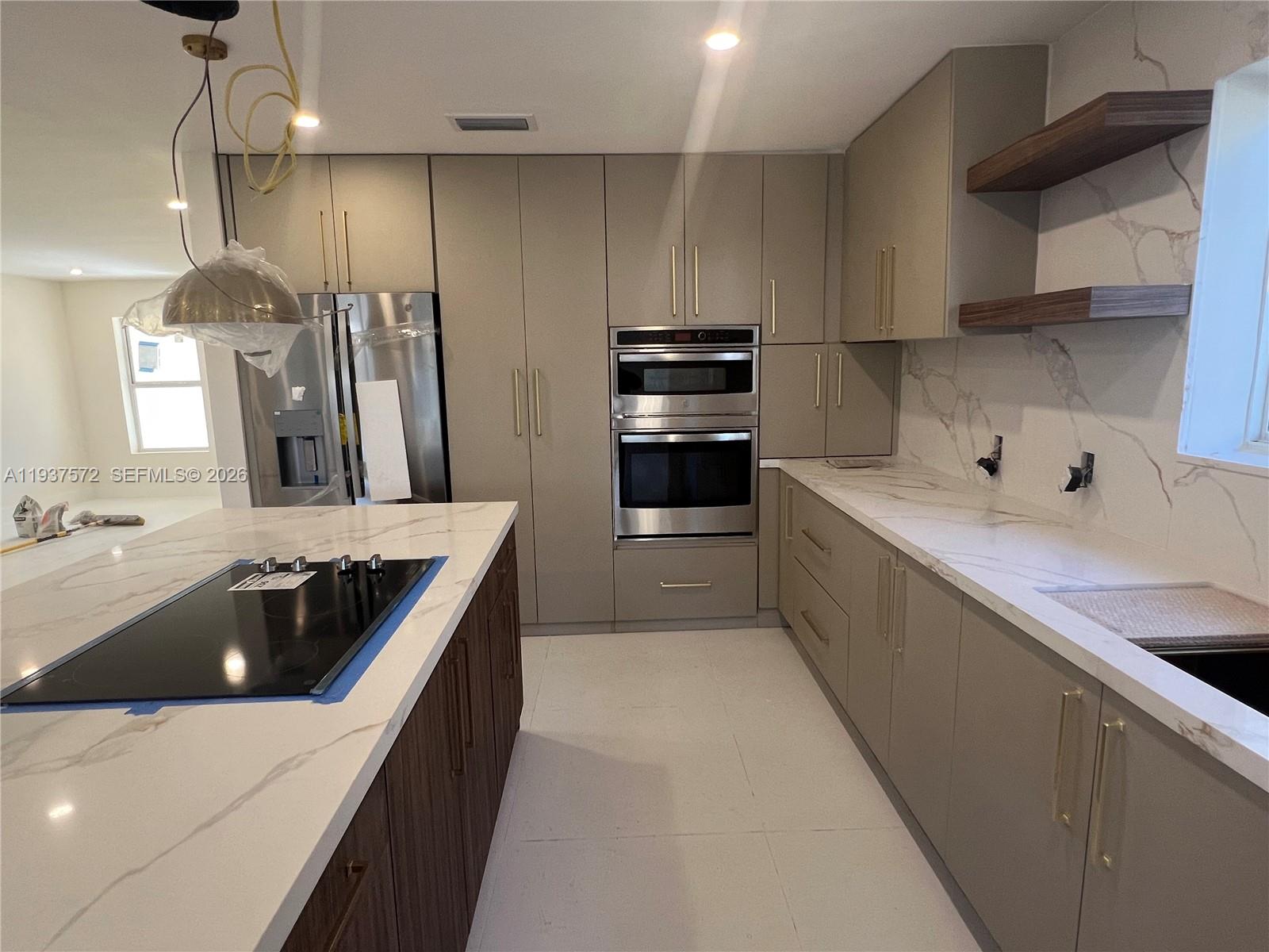 2315 Northwest 3rd Street Miami, FL 33125 - Photo 11 of 15 a kitchen with kitchen island a sink dishwasher stove and refrigerator with wooden cabinet
