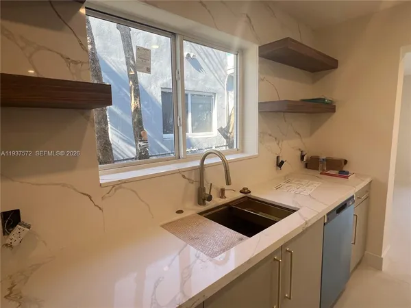 a utility room with a sink dryer and window