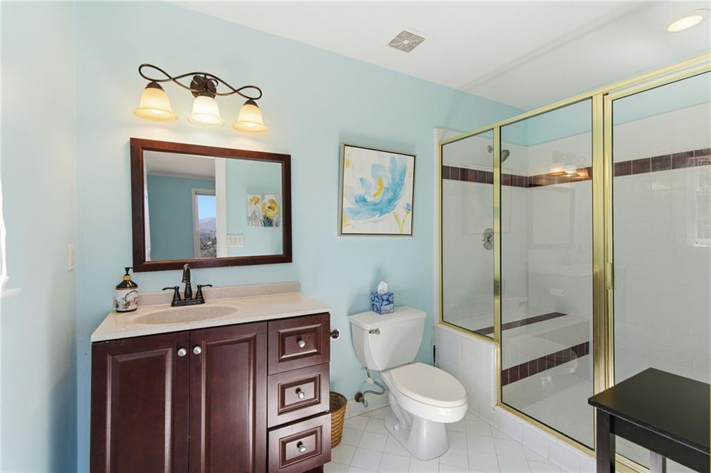 1015 Eagle Ridge Road Dawsonville, GA 30534 - Photo 25 of 64 a bathroom with a toilet sink vanity and mirror