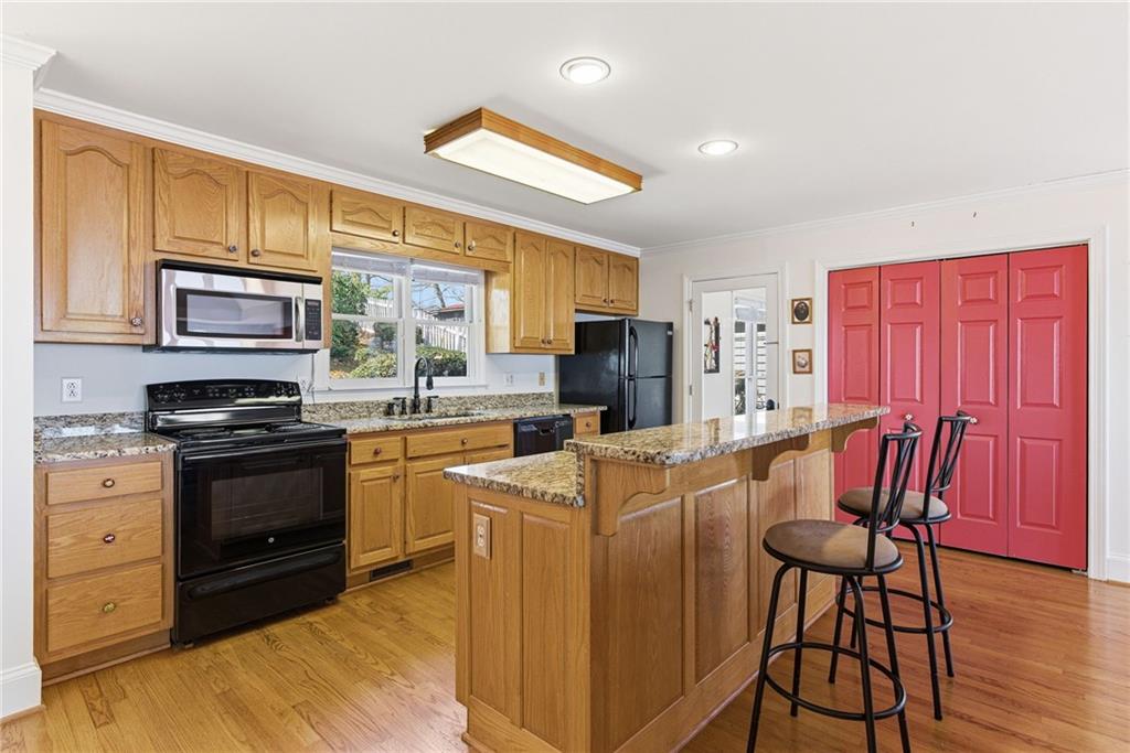 1015 Eagle Ridge Road Dawsonville, GA 30534 - Photo 4 of 64 a kitchen with stainless steel appliances granite countertop a stove a refrigerator a sink dishwasher a dining table and chairs with wooden floor