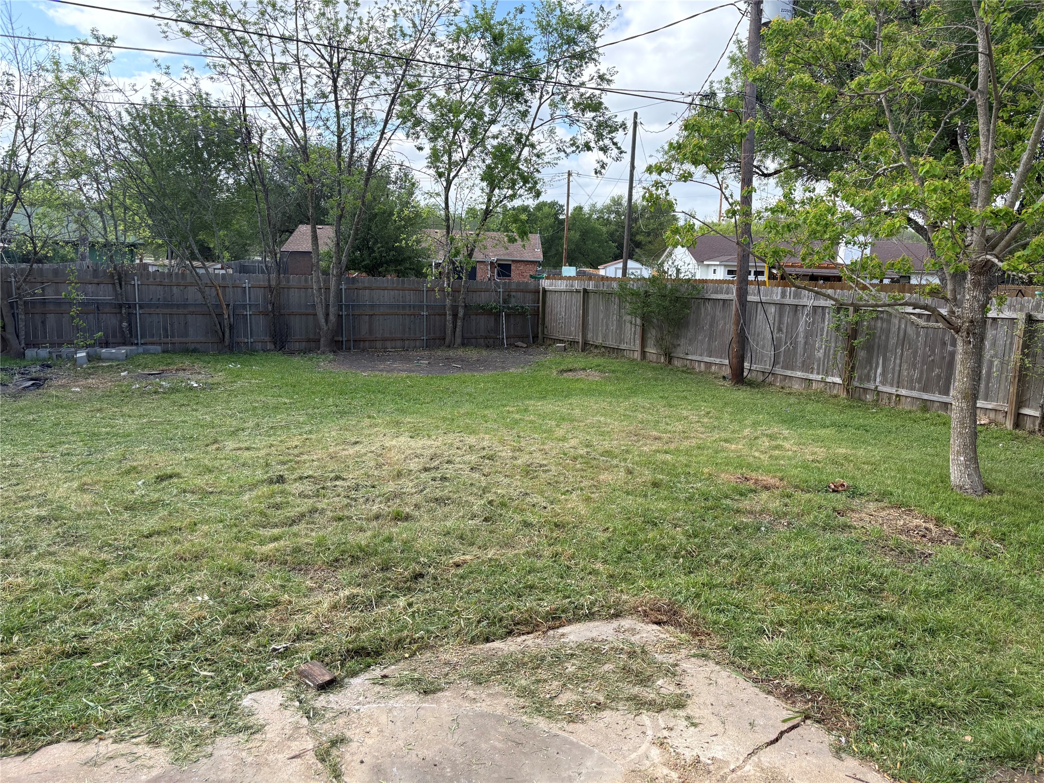 709 Drake Lane Taylor, TX 76574 - Photo 13 of 17 a view of a backyard with large trees and wooden fence