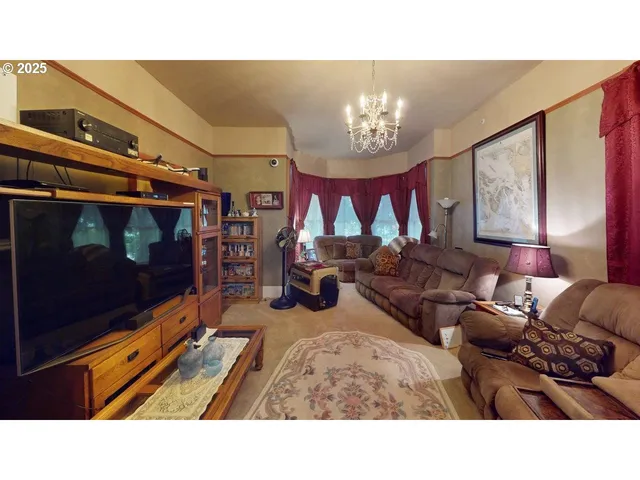 a living room with furniture a chandelier and a flat screen tv