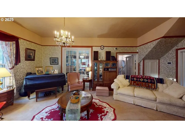 a living room with furniture a chandelier and a piano