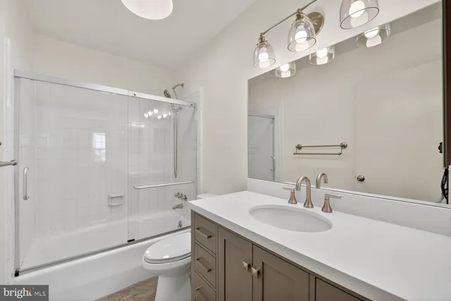 a bathroom with a sink a toilet and a large mirror