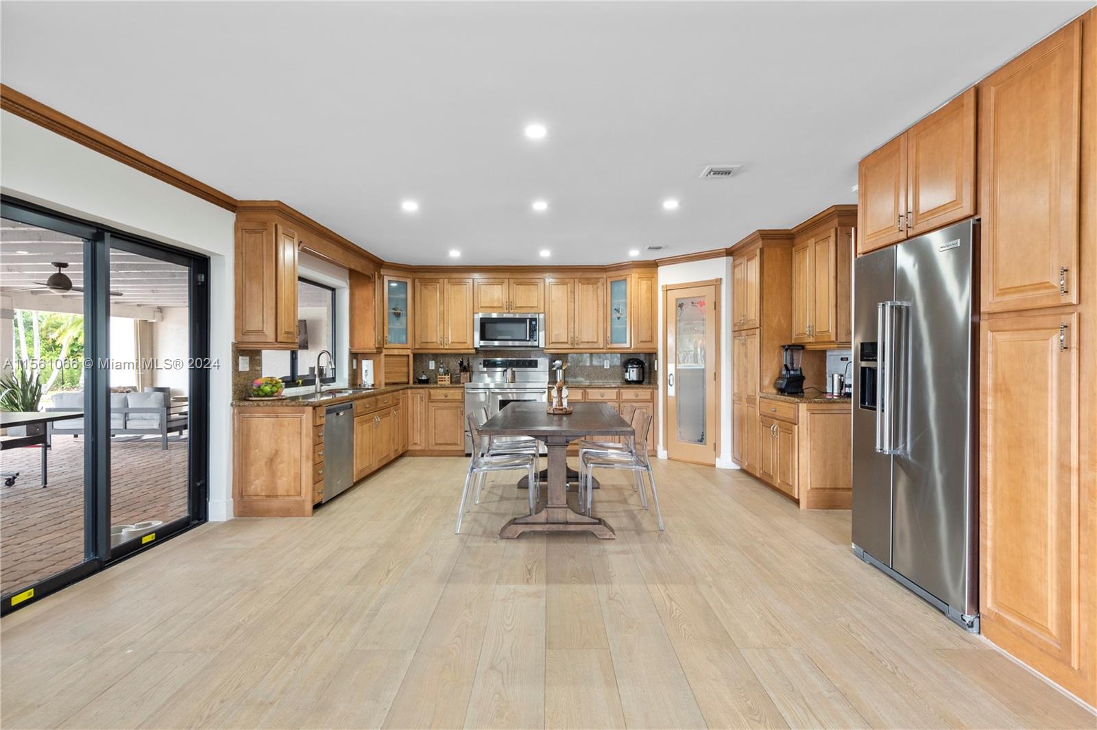 501 Ranch Road Weston, FL 33326 - Photo 15 of 50 a dining room with stainless steel appliances granite countertop furniture wooden floor and a view of kitchen