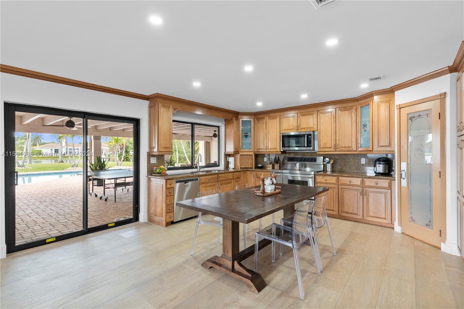 501 Ranch Road Weston, FL 33326 - Photo 16 of 50 a kitchen with a table chairs refrigerator and microwave