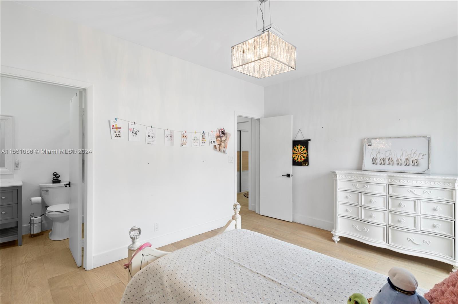 501 Ranch Road Weston, FL 33326 - Photo 31 of 50 a bedroom with a bed and a chandelier