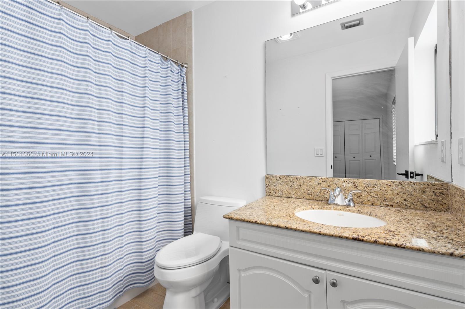 501 Ranch Road Weston, FL 33326 - Photo 39 of 50 a bathroom with a granite countertop toilet a sink and a mirror