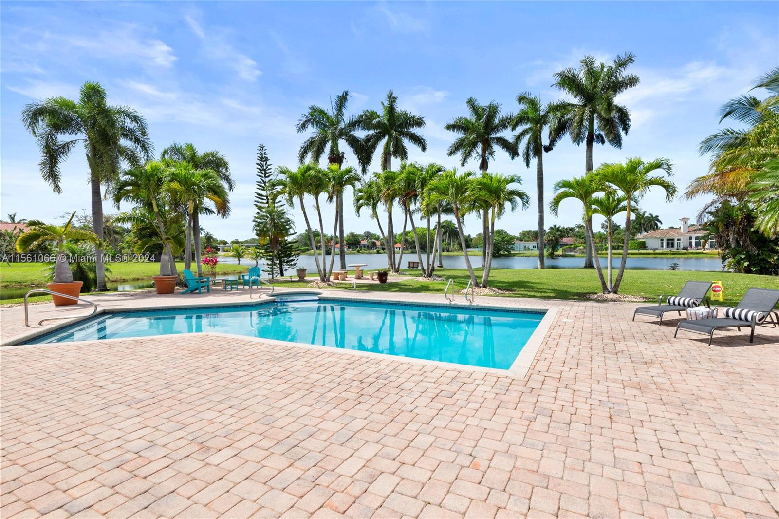501 Ranch Road Weston, FL 33326 - Photo 46 of 50 a view of a swimming pool with a lounge chair and palm trees