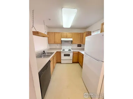 a kitchen with a sink a refrigerator and cabinets