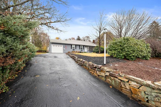 a view of a house with backyard and trees