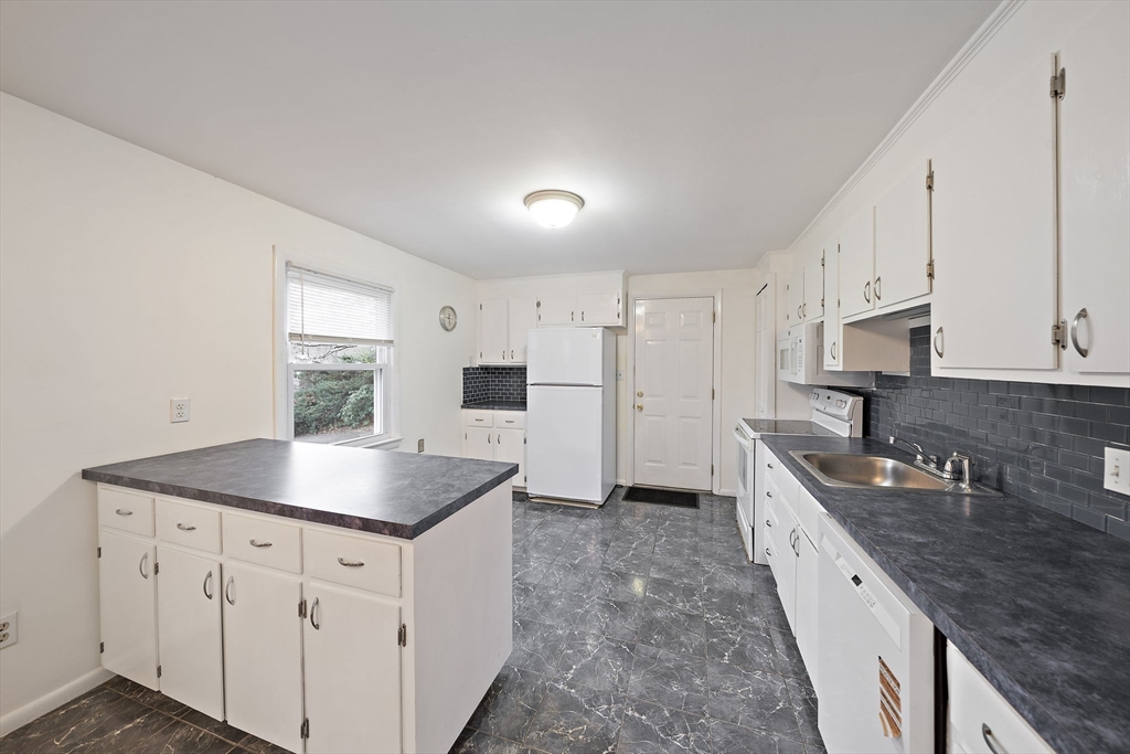 12 Stellar Road Braintree, MA 02184 - Photo 4 of 25 a kitchen with stainless steel appliances granite countertop a sink dishwasher and white cabinets with wooden floor