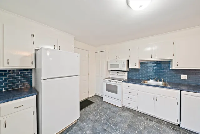 a white refrigerator freezer sitting inside of a kitchen