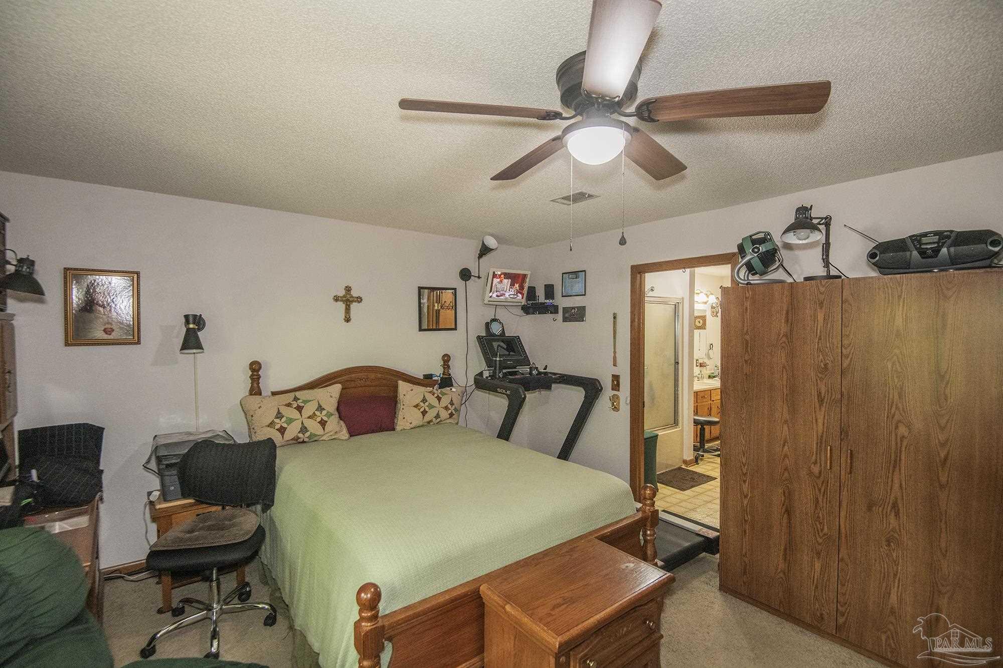 1210 Goldenrod Road Cantonment, FL 32533 - Photo 19 of 50 a bedroom with a bed and a chandelier