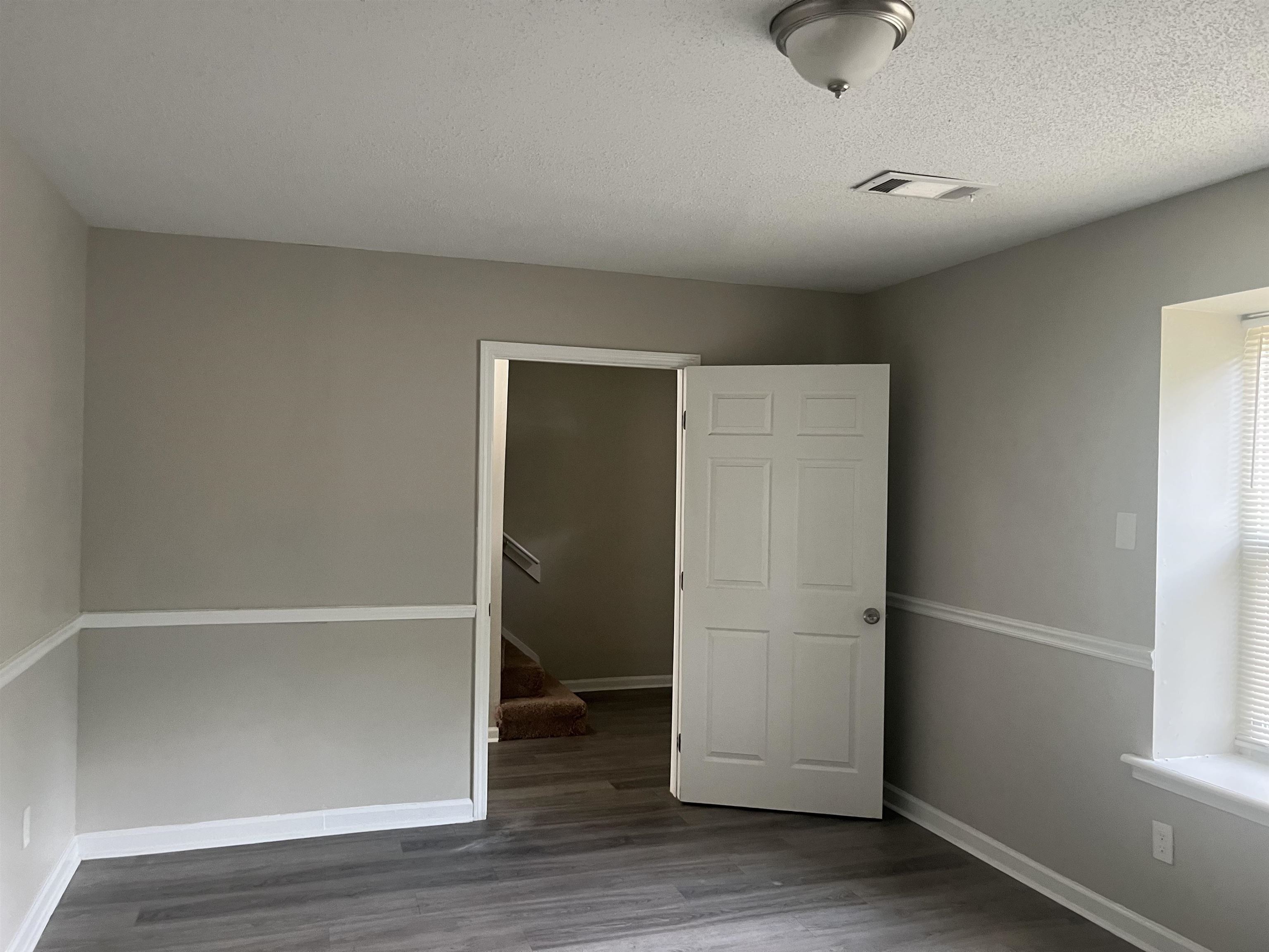 5994 Lofty Oak Road, Unit 5994 Memphis, TN 38115 - Photo 3 of 3 Unfurnished bedroom featuring dark wood finished floors and a textured ceiling