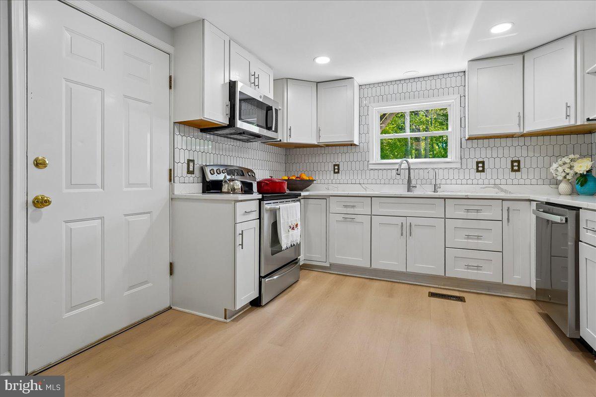 523 Widewater Road Stafford, VA 22554 - Photo 17 of 57 a kitchen with stainless steel appliances a sink a stove a refrigerator cabinets and a window