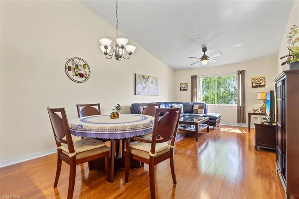 a view of a dining room with furniture a chandelier and wooden floor