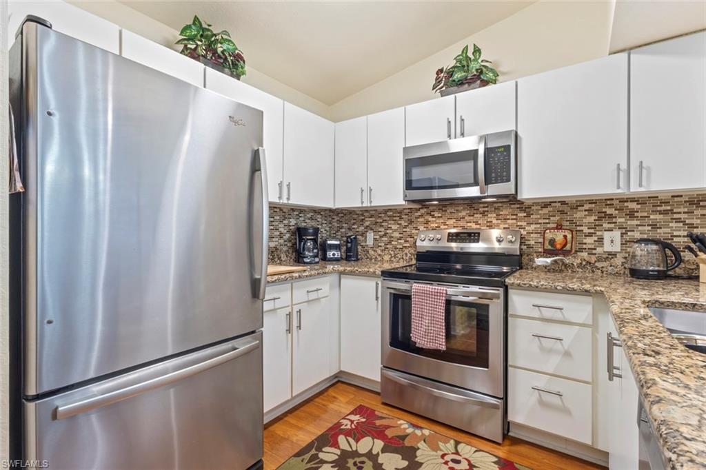 8288 Key Royal Lane, Unit 1435 Naples, FL 34119 - Photo 8 of 26 a kitchen with stainless steel appliances a refrigerator sink and microwave
