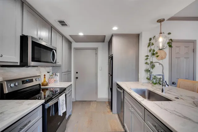 a kitchen with stainless steel appliances granite countertop a sink stove and refrigerator