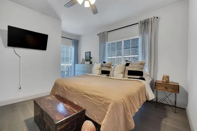 a bedroom with a bed tv and a window