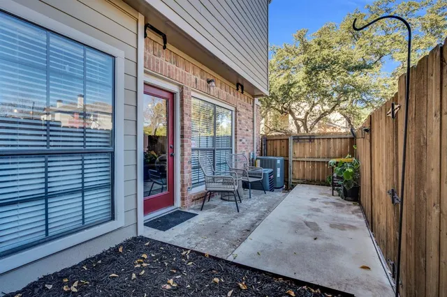 a view of a porch with a table and chairs and wooden fence