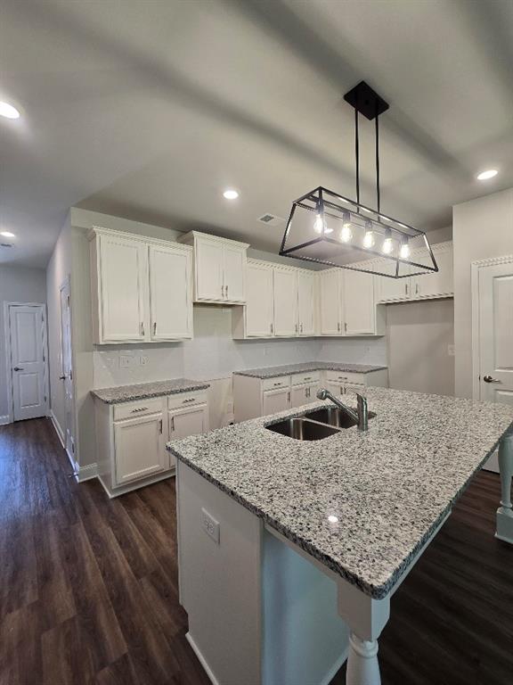 6210 Ripple Way, Unit 90 Atlanta, GA 30349 - Photo 13 of 23 a kitchen with granite countertop kitchen island stainless steel appliances a sink stove and wooden floor