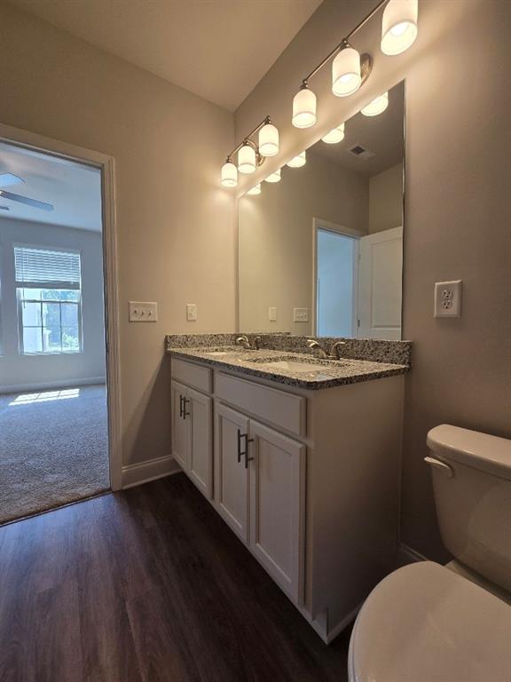 6210 Ripple Way, Unit 90 Atlanta, GA 30349 - Photo 20 of 23 a bathroom with a granite countertop toilet sink and mirror