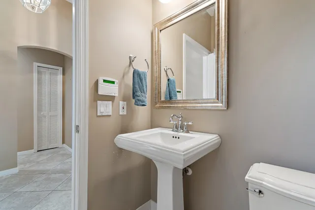 a bathroom with a toilet sink and mirror