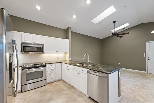 a kitchen with stainless steel appliances granite countertop a stove a sink and a refrigerator