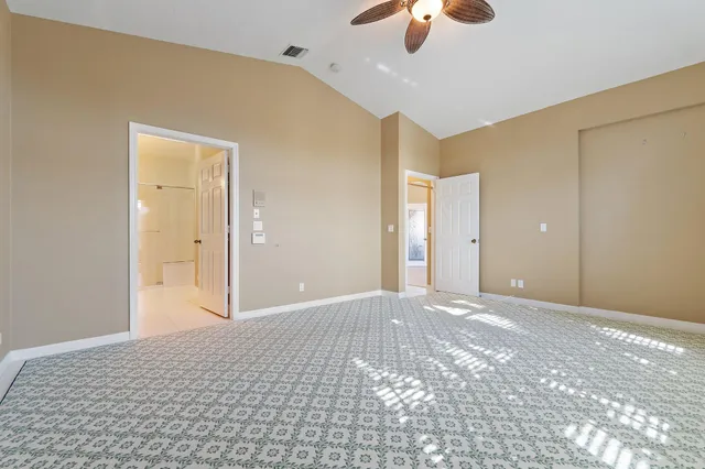 a view of a big room with windows and chandelier fan