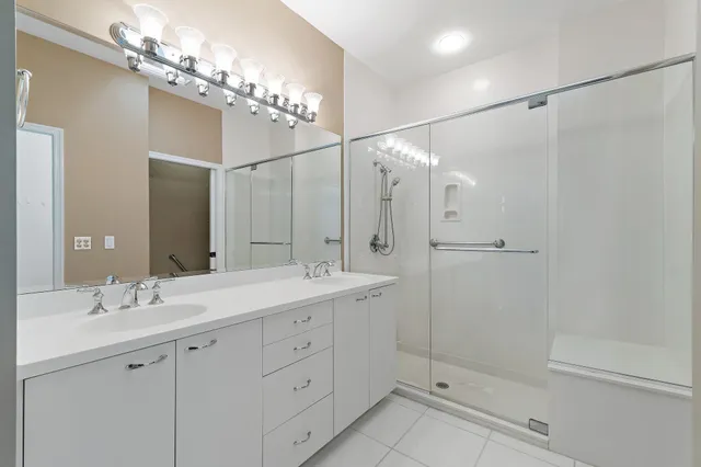 a bathroom with a double vanity sink mirror and shower