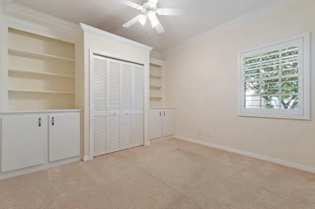 an empty room with windows and cabinet