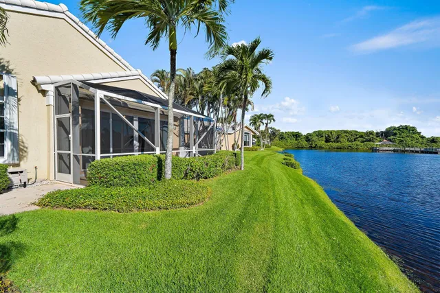 a view of a house with a yard and potted plants
