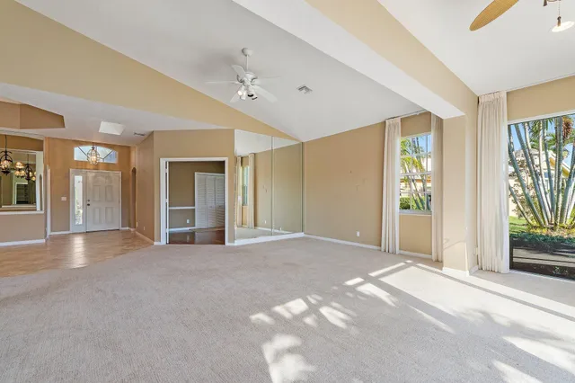 a view of an empty room with glass door and windows