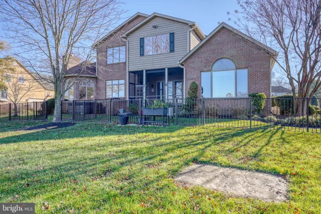 a view of an empty room with wooden floor and a chandelier