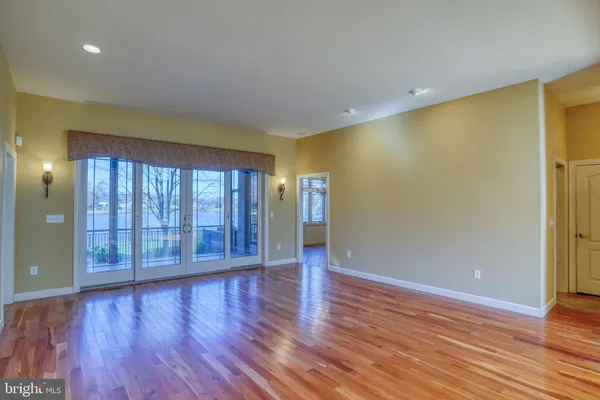 a view of an empty room with wooden floor and closet