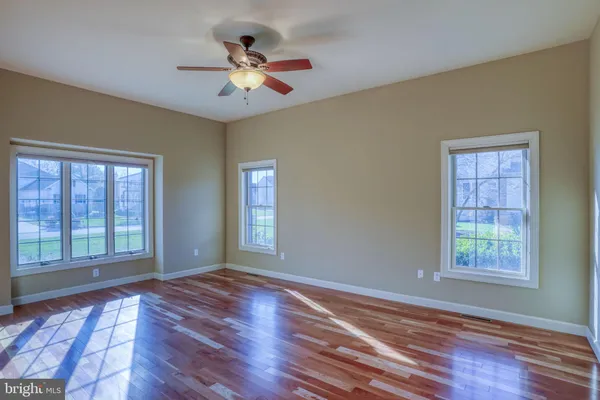 a view of room with a ceiling fan and wooden floor