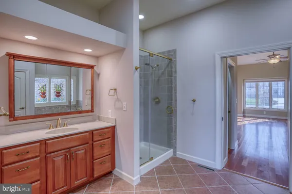 an empty room with windows and ceiling fan
