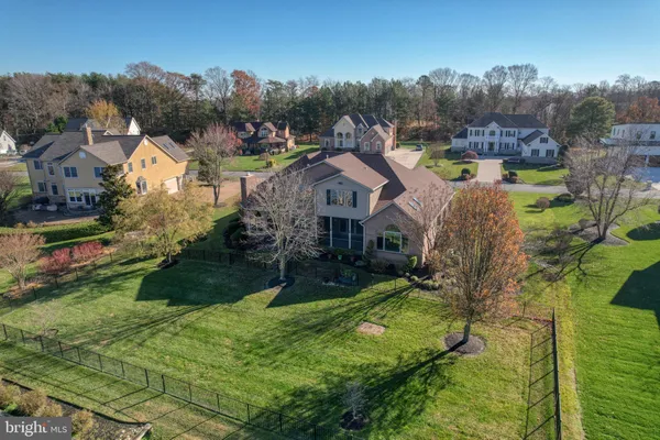 an aerial view of residential houses with outdoor space and trees