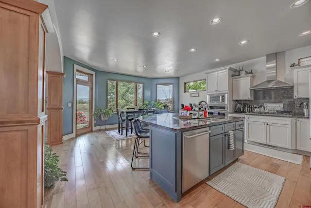 a kitchen with stainless steel appliances granite countertop a stove and cabinets