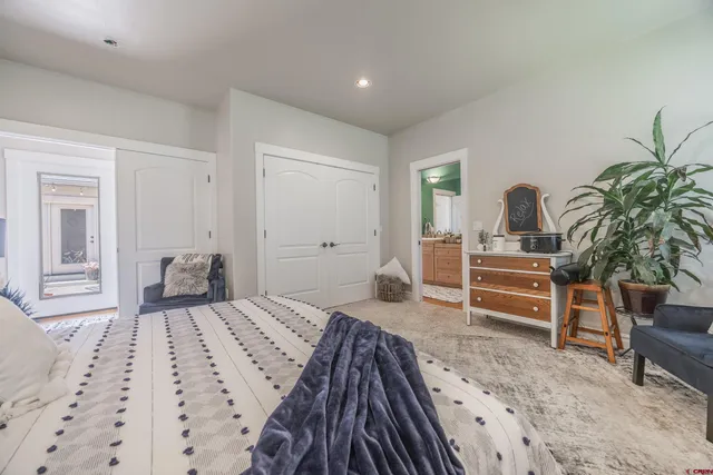 a bedroom with a bed and a large mirror on the dresser