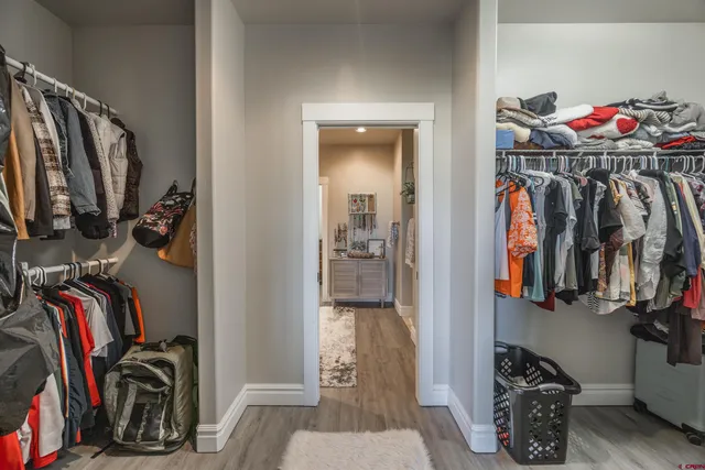 a view of walk in closet with clothes and shoes