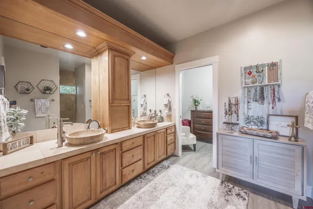a large bathroom with double vanity sinks a large mirror and a shower