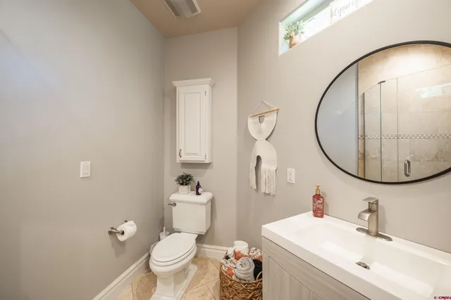 a bathroom with a sink a toilet and a mirror