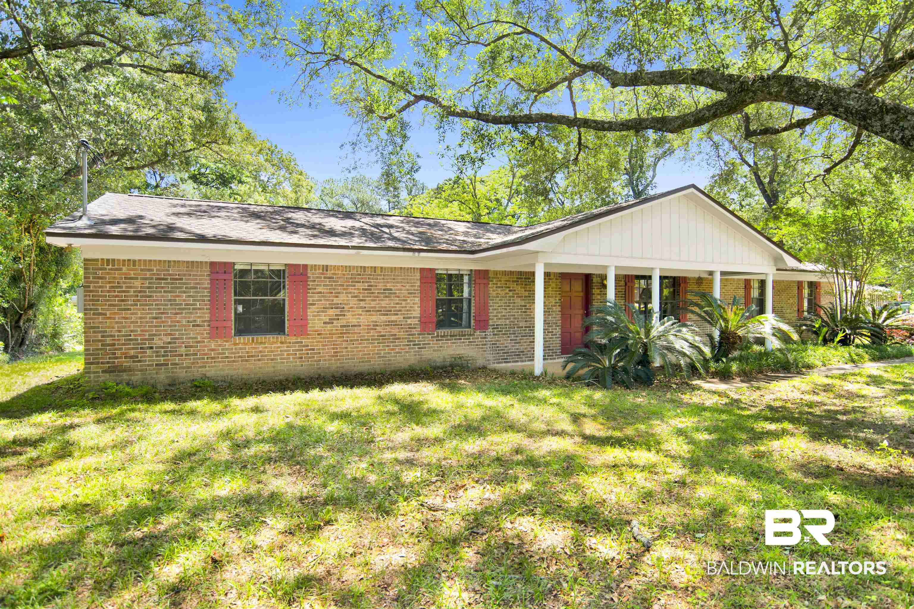 30888 Cemetery Road Daphne, AL 36527 - Photo 2 of 36 Brick exterior featuring red window shutters and a covered front porch with white columns