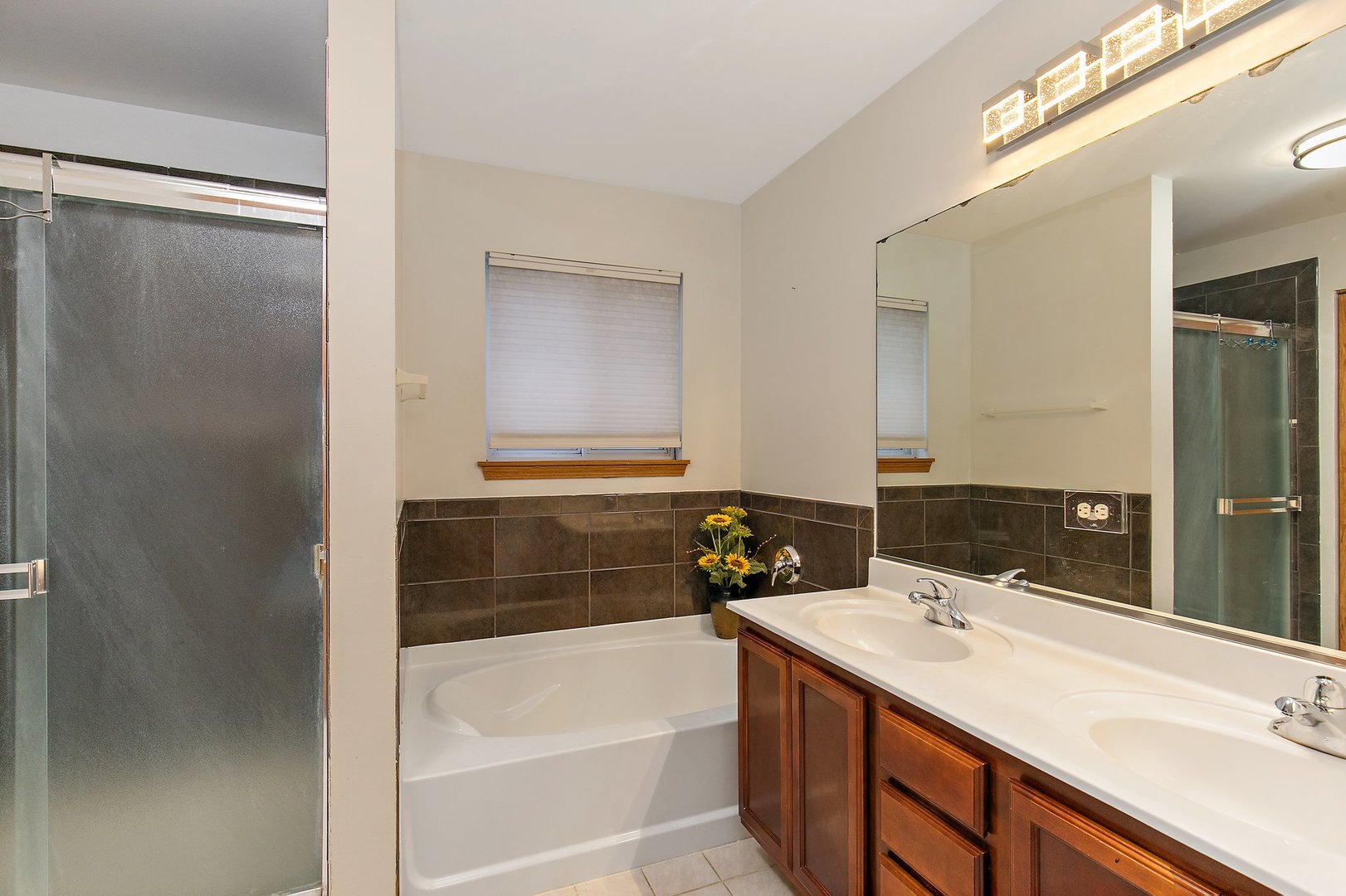 25649 Brooks Farm Road Round Lake, IL 60073 - Photo 17 of 24 a bathroom with a tub sink and mirror